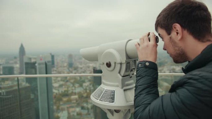 人类通过放大装置单眼在大城市的城市景观中观察