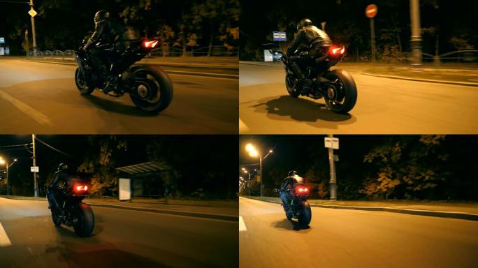 摩托车手在夜路上骑摩托车。戴着头盔的年轻人在晚上的街道上快速骑现代运动摩托车。黄昏时开车的人。自由和