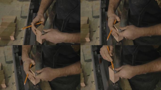 用铅笔和直尺在木板上划线。男性的手与尺子和铅笔特写。在工作的专业木匠。前视图。木工车间的工人。