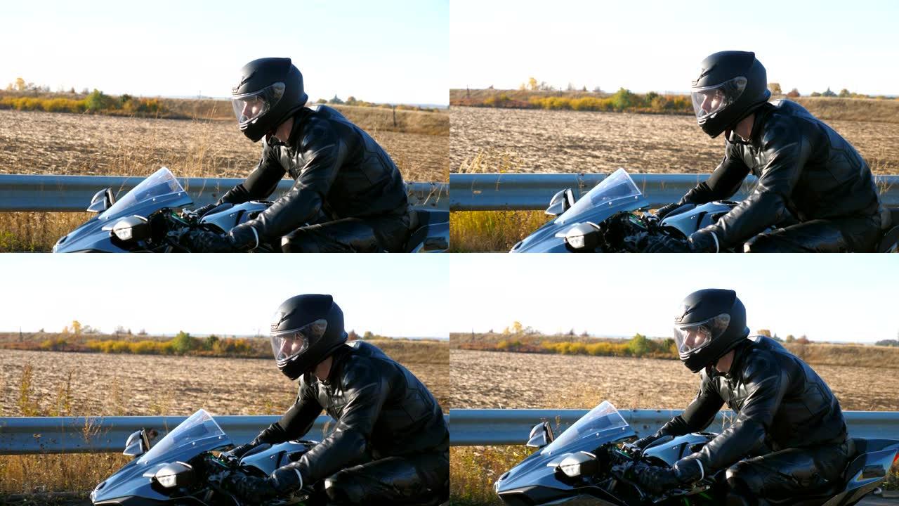 年轻人在高速公路上骑着现代运动摩托车。摩托车手在乡村公路上骑摩托车。旅途中开车的人。自由和冒险的概念