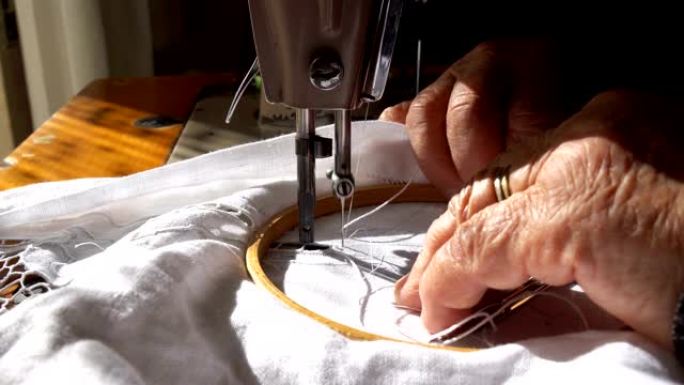 一位老妇人正在用缝纫机工作