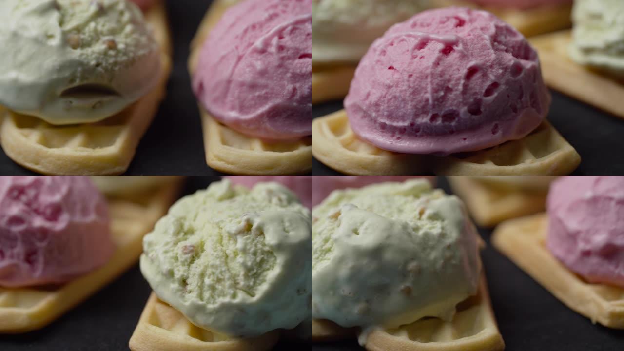 自制华夫饼的特写镜头，彩色冰ream顶部旋转。慢动作在华夫饼上的粉红色和绿色开心果冰ream球。