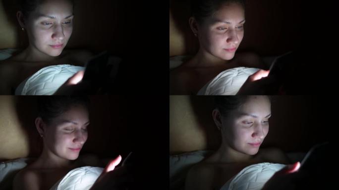 躺在床上的电话上浏览社交网络的女孩