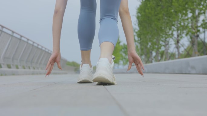 穿着运动装起跑的年轻女性镜头特写