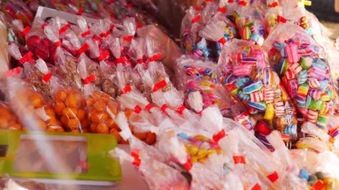 在街头拍卖会上，将五颜六色的糖果装在袋子里。