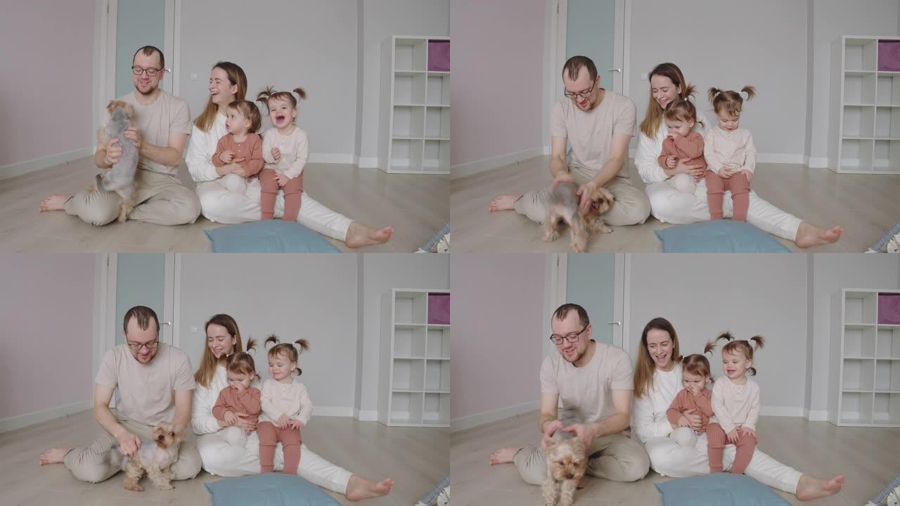 年轻的家庭狗之家。母亲和父亲带着小女儿玩宠物。
