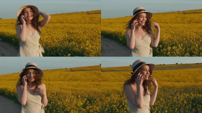 女孩惊讶地接电话，开心地说话。一个微笑的女孩正走过黄色的田野。日落。4k