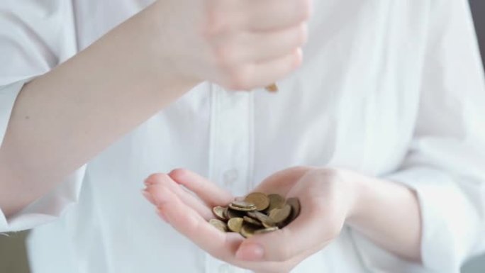 女人把硬币放在手里，计划预算，财政储蓄。经济危机