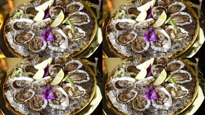 冰牡蛎和柠檬放在淡紫色剑兰花瓣的金色拼盘上