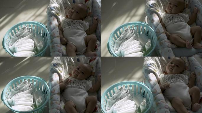 刚出生的婴儿躺在床上，卧室里有婴儿配件衣服