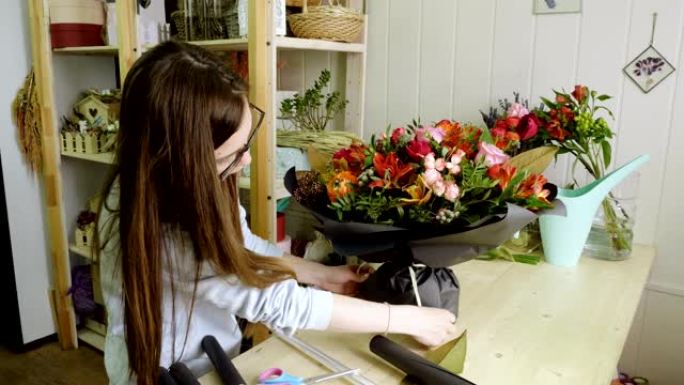 女性高加索花店在花店里做一束鲜花。4K