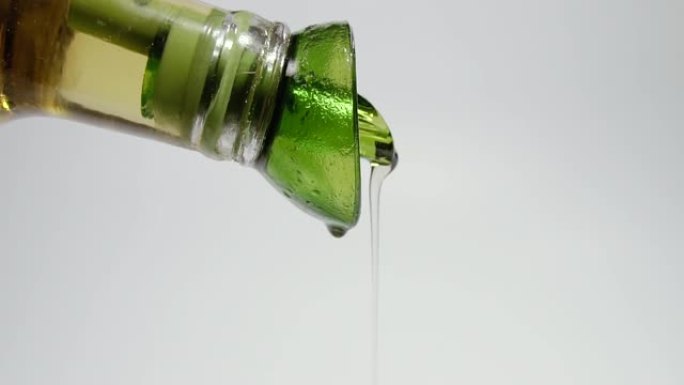 橄榄油。一股橄榄油从玻璃瓶中倒出。慢动作拍摄。