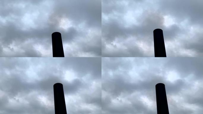 烟雾来自黑色的工厂烟囱，面对灰色的多云天空。木材加热产生的烟雾。大气污染。环境问题。