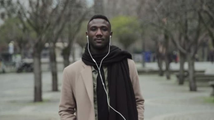 城市公园里戴耳机的黑人肖像
