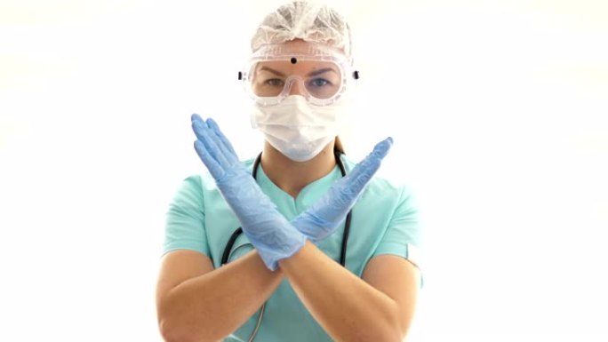 戴着医用口罩和安全眼镜的女医生用自己的双手做了一个禁止的标志。冠状病毒流行病