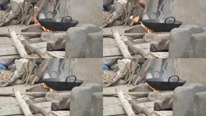 室外印度厨房在木头燃烧的火上烹饪面包。查帕蒂·纳安