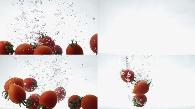 新鲜健康的樱桃番茄的特写镜头落入清澈的水中，白色背景上有很大的飞溅。一次为您的项目拍摄3个剪辑