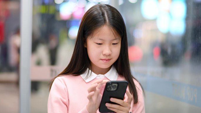 女孩使用智能手机在城市街道