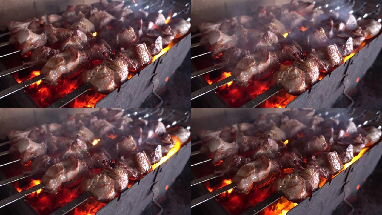 在大自然的火上在烤串上煮烤肉串。在村子里的乡下大火上准备烤肉串。生肉在木炭烤架上煮熟