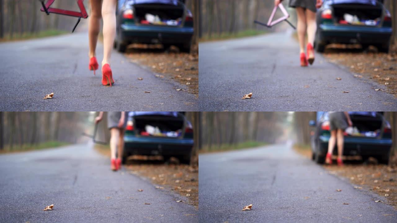 4 k。性感女人的腿在红色高跟鞋和汽车故障标志