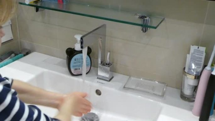 年轻可爱的男孩在家洗手。