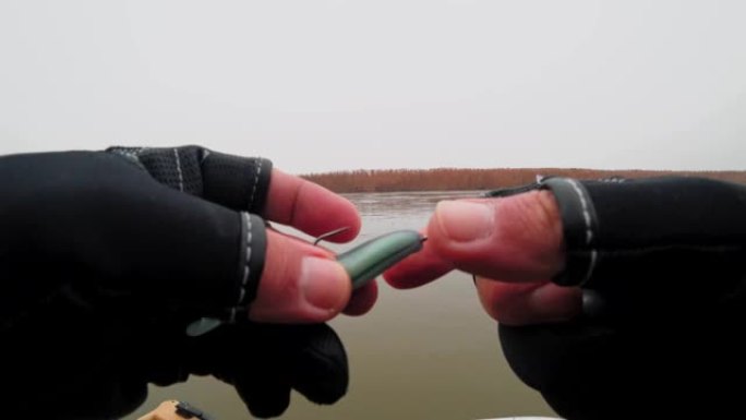 垂钓者准备硅胶诱饵和铅货物在河上钓鱼