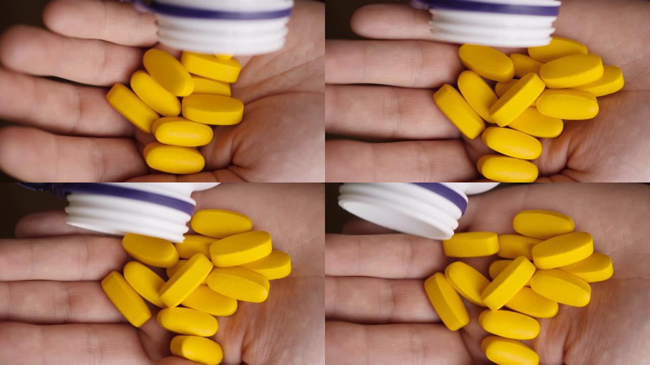 维生素和补充剂。手握各种黄色药丸。慢动作。药物片剂，胶囊从手。抗抑郁药，头痛，过敏，抗生素心脏病发作