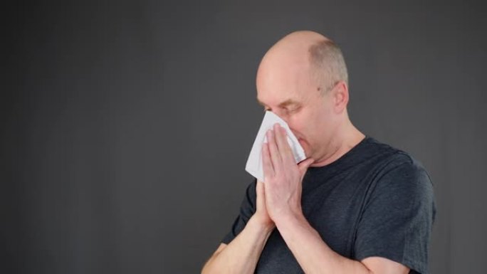 咳嗽的人在黑色背景上的餐巾纸上吹鼻子。流感流行时，冷冰冰的人打喷嚏和鼻涕。Simptoss新型冠状病