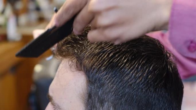 年轻人在理发店或发廊进行发型设计和理发。主人在理发店剪头发