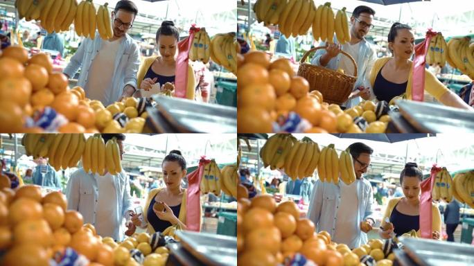 年轻夫妇在农贸市场买水果。
