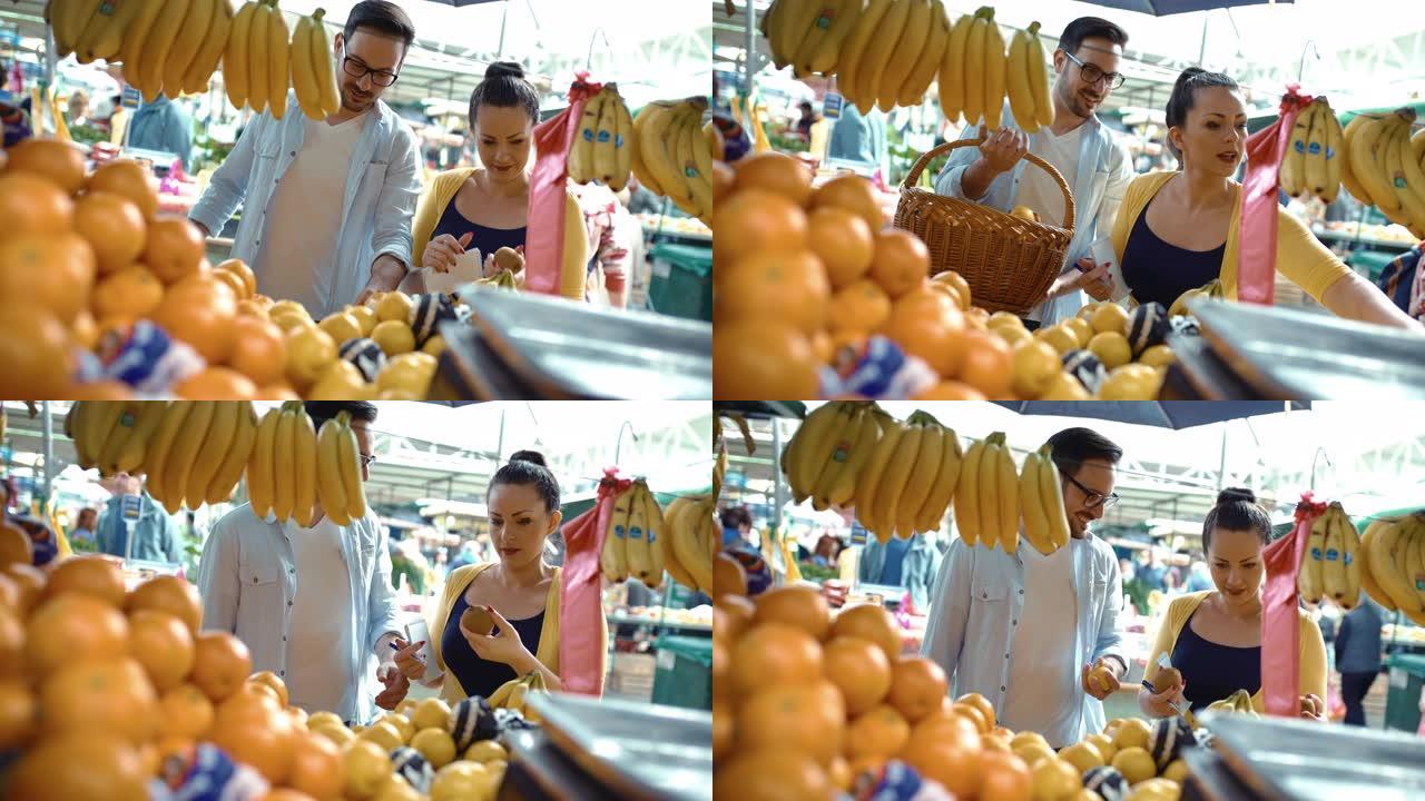 年轻夫妇在农贸市场买水果。