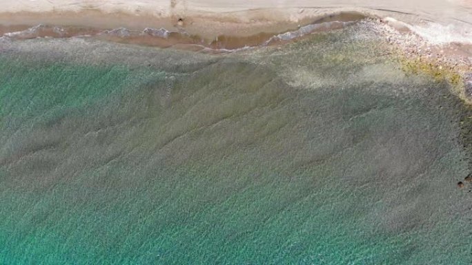 在塞浦路斯利马索尔，一名游泳者注视着静止的无人机，直视着海浪。