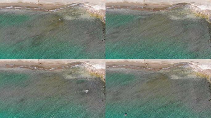 在塞浦路斯利马索尔，一名游泳者注视着静止的无人机，直视着海浪。