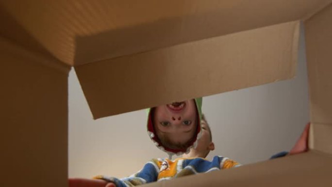 两个男孩打开纸箱。内部视图。