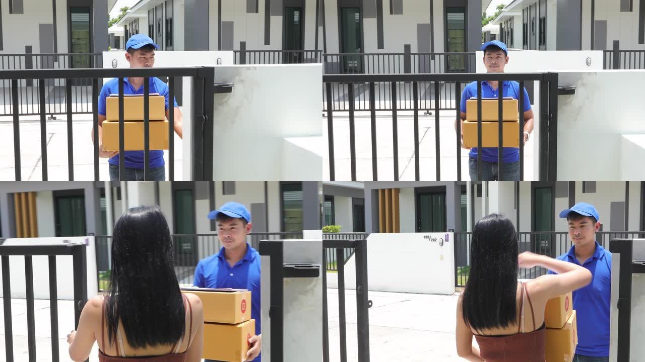 亚洲送货服务人员穿着蓝色制服，戴着蓝色帽子和面罩，处理纸板箱，送给屋前的女顾客。网购快递