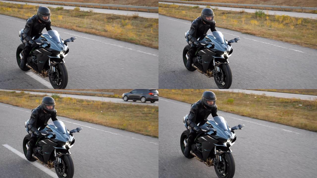 摩托车手在乡村公路上骑摩托车的俯视图。戴着头盔的年轻人在高速公路上快速骑现代运动摩托车。旅途中开车的