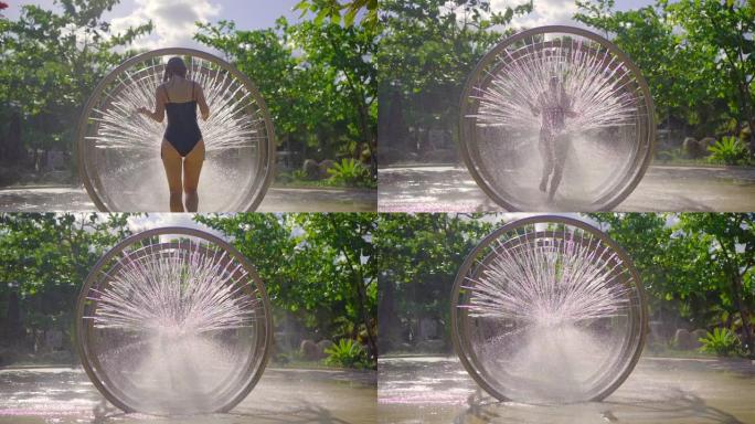 一名年轻女子在水上公园 (aqua park) 穿过圆形按摩淋浴。慢动作镜头