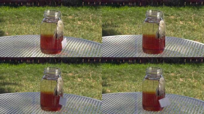 在一个有风的夏日，在外面露台桌子上的梅森罐子里煮太阳茶。