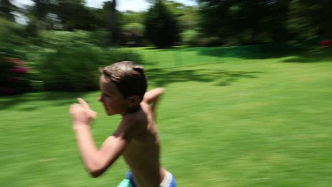 活跃的男孩在家庭草坪上奔跑并跳入游泳池水中