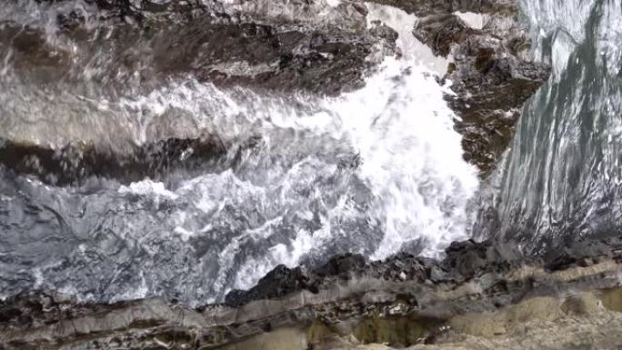 海浪冲入狭窄的岩石缝隙