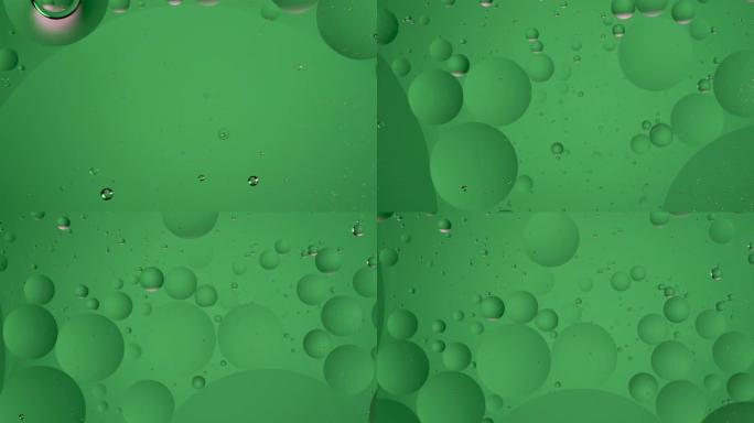 漂浮在水中的绿色球体油泡。液体中顺时针循环运动，气泡宏观射击。抽象智能手机主屏幕风格，主题或背景，翠