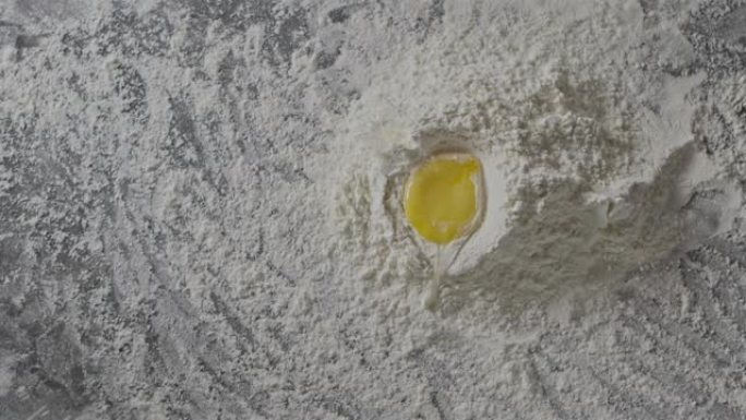鸡蛋落入面粉堆的慢动作。主页的准备