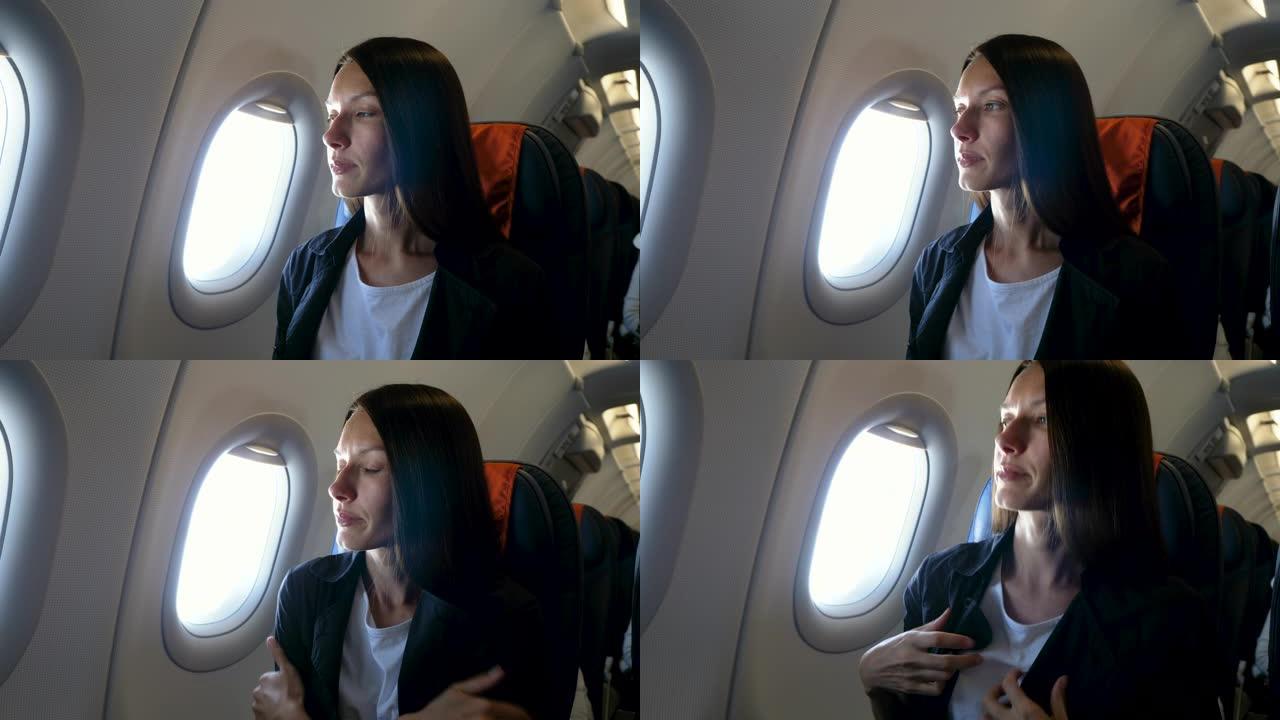 一个年轻漂亮的女人坐在窗边，在飞机上冻僵了。4K