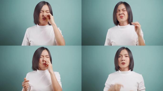 亚洲妇女因发热打喷嚏而生病，并被隔离在蓝色背景上的薄纸擦拭鼻涕。医疗保健概念。4k视频。