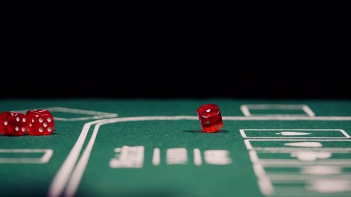 黑色背景的绿色扑克桌上红色掷骰子的特写