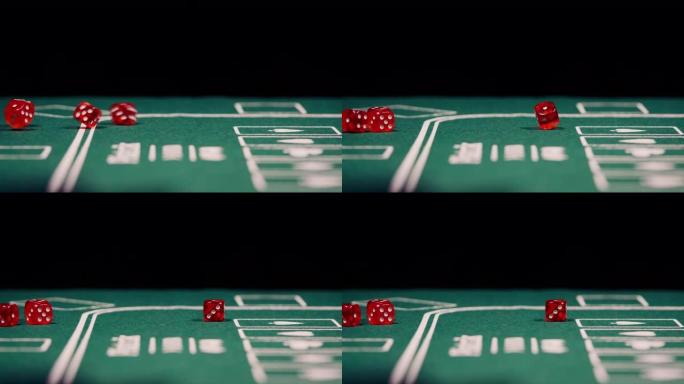 黑色背景的绿色扑克桌上红色掷骰子的特写