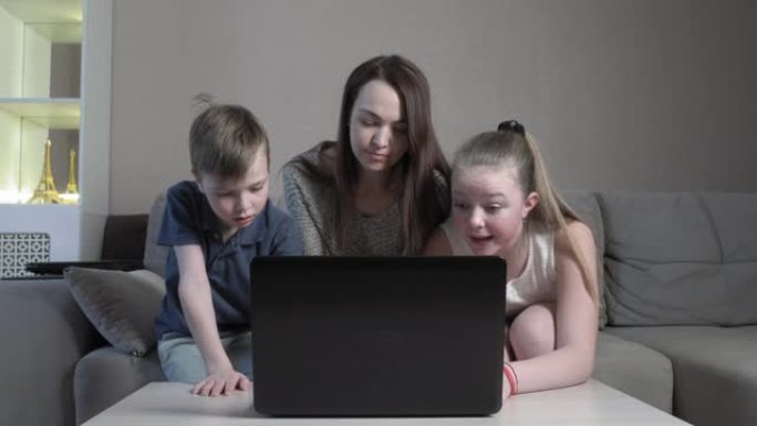 在COVID 19大流行期间，专注可爱的男孩和女孩和他们的妈妈在电脑考试的应用程序中在线使用笔记本电