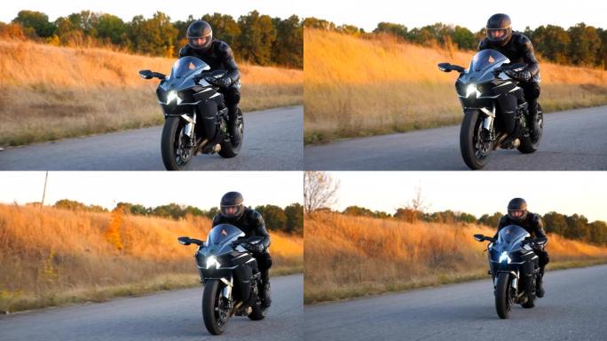 摩托车手在秋天的乡间小路上骑摩托车。戴着头盔的年轻人在高速公路上快速骑现代运动摩托车。旅途中开车的人