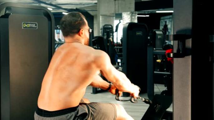 一个有吸引力的男子健美运动员在运动健身房做力量锻炼-减轻体重