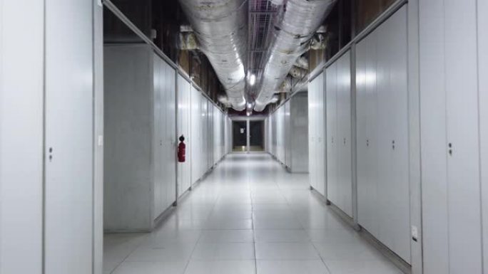 缓慢走下工业建筑内一个空的人工照明走廊稳定